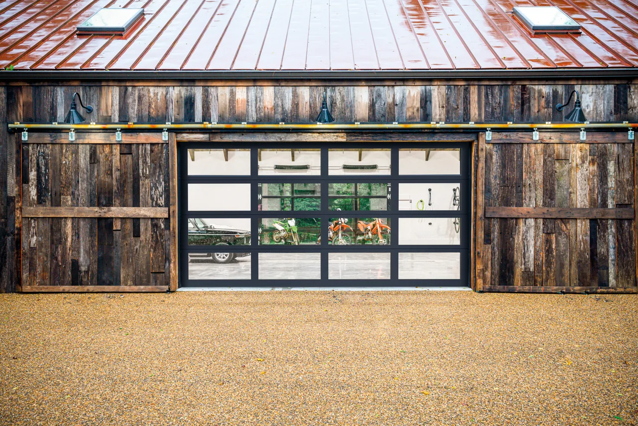 Clopay Avante aluminum and glass door between wood barn doors
